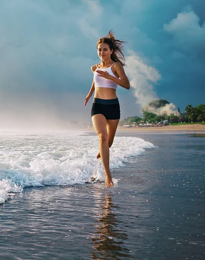 a woman running on the beach