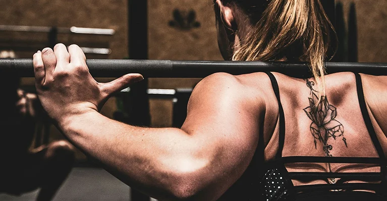 a woman lifting weights on her back
